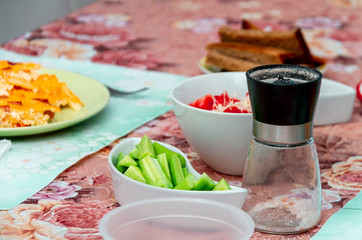 Breakfast. Various colorful breakfast dishes on plates with cutlery.
Omelet, cucumbers, tomatoes, salt shaker and bread.

