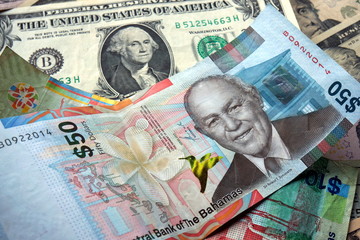 50 Bahamian dollar (BSD) bill surrounded by US dollar bank notes 
