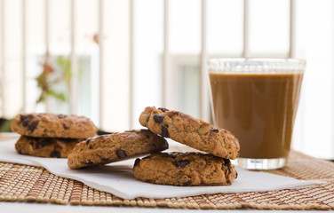 cookies with chocolate and hazelnuts and coffee with milk lie on the table