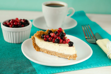 New York style Cheesecake on white plate decorated with fresh berries, on table with copy space so sweet and delicious. Homemade bakery concept.