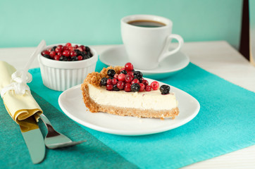 New York style Cheesecake on white plate decorated with fresh berries, on table with copy space so sweet and delicious. Homemade bakery concept.