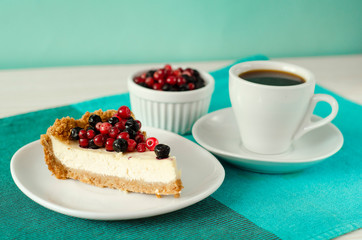 New York style Cheesecake on white plate decorated with fresh berries, on table with copy space so sweet and delicious. Homemade bakery concept.