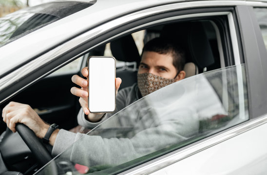 Mockup. A Male Driver In His Car Shows A Special Digital Pass Document In His Smartphone. The Concept Of Free Movement Around The City In The Context Of The Coronavirus Epidemic COVID 19
