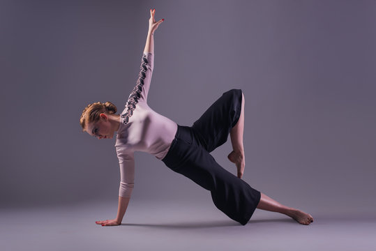 young beautiful dancer posing on a studio background