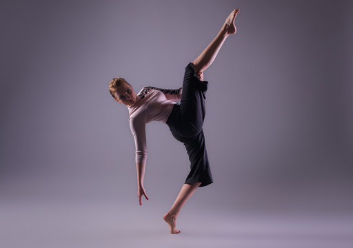 young beautiful dancer posing on a studio background