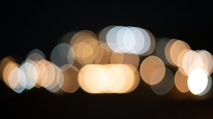 White and orange holiday bokeh. Bokeh photo of LED light. Abstract defocused of white and yellow LED light on black background. White and yellow bokeh. 