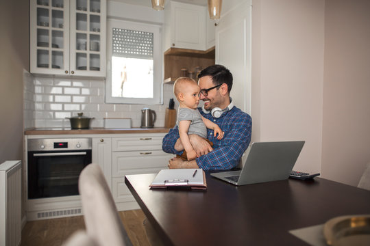 Father taking a break from work to cuddle with his baby boy.