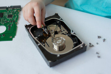 An inquisitive child is experimenting with a broken hard drive