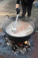 Cooking pot over campfire, stew preparing open grill steaming. Outdoor fireplace camping concept.