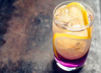 Gin based colorful cocktail with lemon and lavender liqueur on the rustic background. Selective focus. Shallow depth of field.