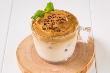 Whipped dalgona coffee with 
spearmint on a white wood background,   copy space