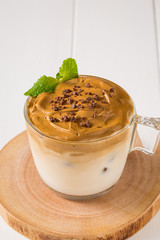 Whipped dalgona coffee with 
spearmint on a white wood background,   copy space