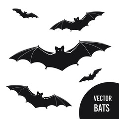 Black silhouettes of flying bats set on white background. Flittermouse night creatures. Flying black bats traditional Halloween symbols