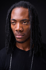 Face of young handsome African man with dreadlocks