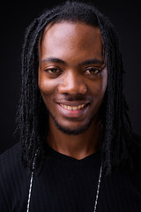 Face of young handsome African man with dreadlocks
