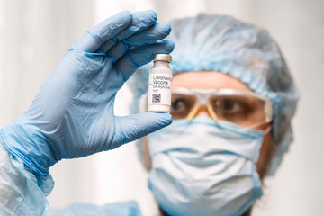 Coronavirus vaccine. Doctor with a vaccine. Hands holding a coronavirus vaccine ampoule, Covid-19