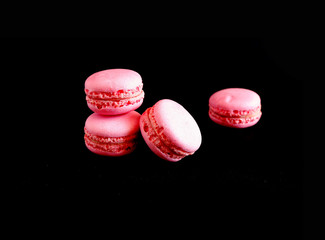 Pink macaroons on a black background. Suitable for advertising background