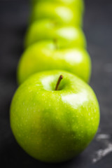 Close-up green apples on the rustic wooden background. Selective focus. Shallow depth of field.