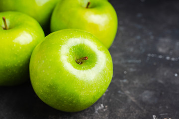 Close-up green apples on the rustic wooden background. Selective focus. Shallow depth of field.