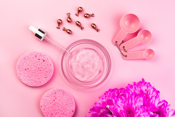 Obraz na płótnie Canvas Beauty accessories for home spa. Flat lay on pink background. Hyaluronic gel, cosmetic ampoules, pipette, sponges, measuring spoons, flowers. Salon wellness procedures, beauty routine, mask, face care