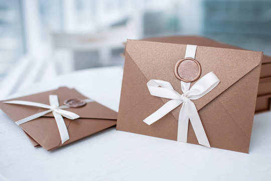 Gift Certificate, Gift Voucher Or Discount. Close-up Photo Of Bronze Invitation Envelope With A Ribbon And Wax Seal, A Gift Certificate, A Card, A Wedding Invitation Card