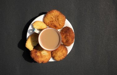 Top View of Tea Cup and Homemade Semolina Cookies in a Plate Isolated on Black Background with Copy Space