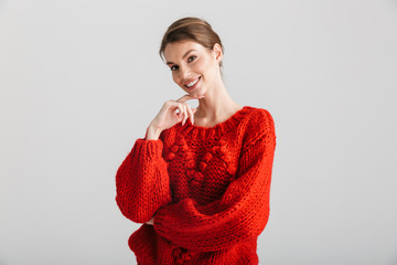 Image of joyful woman in red sweater smiling and looking at camera