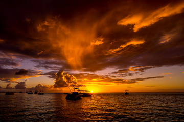 fabulous view of the sunset in Mauritius. Fishing boats on the background of mountains and the setting sun