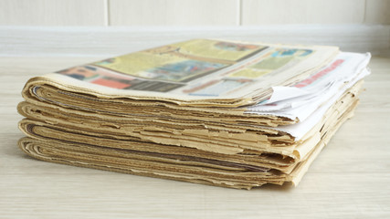 Pile of Newspapers on the Table at Office. Latest Financial and Business News in Daily Paper. Pages with Information (headlines, articles, photos, text). Folded and stacked journals   