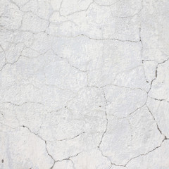 the white wall of an old house with beautiful cracks from time. white paint and whitewash on the wall. the background is white with soft blue and yellow. white old wall background