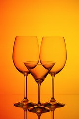 Three glasses for wine on an orange background
