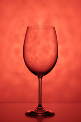 One wine glass on a red background