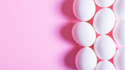 White egg on pink background. minimal concept. top view