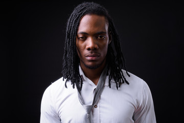 Face of young handsome African businessman with dreadlocks