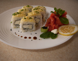 cheese sushi rolls on a white plate with ginger and wasabi, veggie food close up