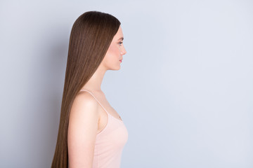 Fototapeta premium Profile photo of pretty perfect appearance model lady not smiling presenting ideal neat long hairstyle look empty space wear beige singlet isolated grey color background