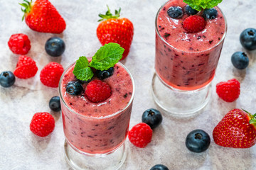 Mixed berry smoothie garnished with fresh fruit and mint