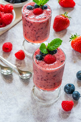 Mixed berry smoothie garnished with fresh fruit and mint