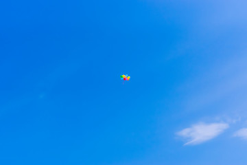 Colored balloons high in bright peaceful blue sky