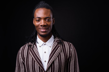 Face of young handsome African businessman in suit with dreadlocks