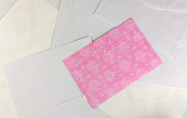 Pink Envelope over Scattered White Envelopes