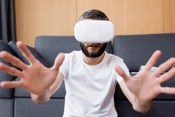 Naklejka premium Selective focus of man using vr headset in living room