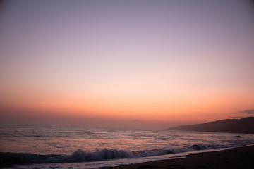 Fototapeta na wymiar Sunset over the Ocean and the Beach