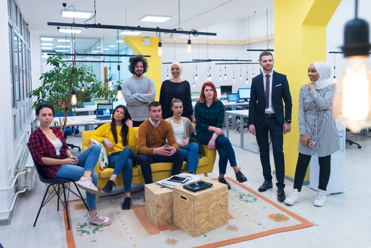 Brainstorm of a group of young experts in the field of economics. Discuss a possible drop in economics in the world in their creative modern office, looking at camera.