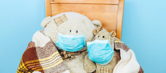 Fototapeta na wymiar teddy bear and hippo in a medical mask on a blue background. Concept of 2019-20 coronavirus Covid-19 pandemic.