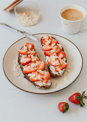 Rye Bread Toasts with Ricotta, Strawberries, Almond and Honey with coffee on white background