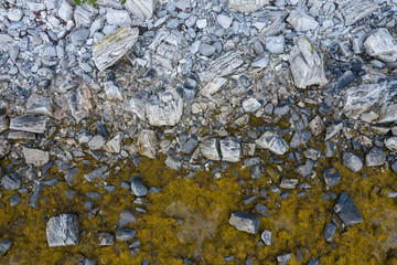 Aerial top view of sea waves hitting rocks on the beach.