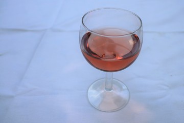 Verre de vin rosé dans un verre ballon transparent sur une nappe blanche - Département du Rhône - France