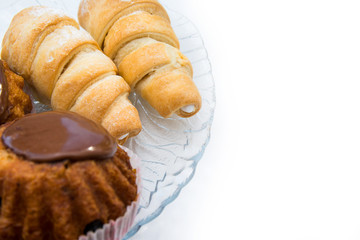 Sweets for tea and coffee, a cake with rum covered with chocolate and a sweet tube with custard