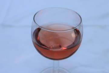 Verre de vin rosé dans un verre ballon transparent sur une nappe blanche - Département du Rhône - France